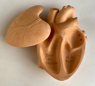 A plaster heart-shaped box with the phrase 'From the bottom of my heart' inscribed on it, in a terracotta color.

House Parts handmade, crafted, artisan, high quality, statues, busts, and garden and animal figurines.  Unique gifts for everyone. Indoor decorations, Outdoor statues and garden items. Fantasy, whimsical, thoughtful gifts, original gift idea, shop small business, plaster, concrete, Clam shell, Gargoyles, Alice in Wonderland, animal lover gifts, pet memorial