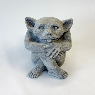 Sitting cement gargoyle statue with bat-like features and his tongue sticking out on a white background. House Parts home decor handmade Atlanta gargoyle grotesque whimsical fantasy mystical creature. Unique gift for fans of fantasy, dungeon, or dinosaurs. Unique Christmas gift for someone who has everything. Gothic, medieval, unique, artisan, craft, detail, specialty, a gift that no one else has, special, protective, female owned business, family small business, local, odd, quirky gifts