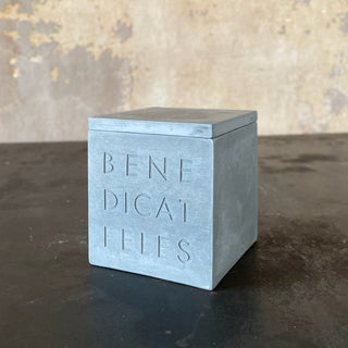 A gray pet memorial urn in the shape of a box with a lid with the inscription 'BENEDICAT FELES' or 'BLESS THE CATS' on the front.

House Parts handmade, crafted, artisan, high quality, statues, busts, and garden and animal figurines.  Unique gifts for everyone. Indoor decorations, Outdoor statues and garden items. Fantasy, whimsical, thoughtful gifts, original gift idea, shop small business, plaster, concrete, Clam shell, Gargoyles, Alice in Wonderland, animal lover gifts