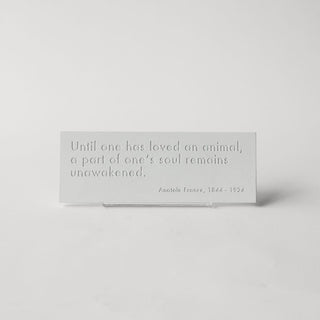 A white plaque with shadowed text with quote from Anatole France "Until one has loved an animal, a part of one's soul remains unawakened." 

House Parts handmade, crafted, artisan, high quality, statues, busts, and garden and animal figurines.  Unique gifts for everyone. Indoor decorations, Outdoor statues and garden items. Fantasy, whimsical, thoughtful gifts, original gift idea, shop small business, plaster, concrete, Clam shell, Gargoyles, Alice in Wonderland, animal lover gifts, pet memorial