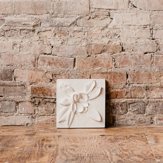 A white plaster cast of a Magnolia bud with leaf details, designed as wall art for home decor. For contrast, the plaque is set against a brick wall

House Parts handmade, crafted, artisan, high quality, statues, busts, and garden and animal figurines.  Unique gifts for everyone. Indoor decorations, Outdoor statues and garden items. Fantasy, whimsical, thoughtful gifts, original gift idea, shop small business, plaster, concrete, Clam shell, Gargoyles, Alice in Wonderland, animal lover gifts, pet memorial