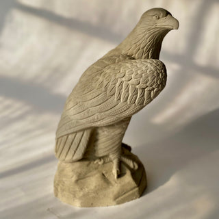 Side view of a hand cast eagle statue with stylish finish, sitting on a base, with a shadow cast across its form. Proud and majestic bird of prey, a symbol of American strength.  A beautifully detailed sculpture.

House Parts handmade, crafted, artisan, high quality, statues, busts, and figurines.  Unique gifts for everyone. Indoor decorations, Outdoor statues and garden items. Thoughtful gift, animal lovers, instead of pet, small business, rabbit, bunny, dog, turtle, frog