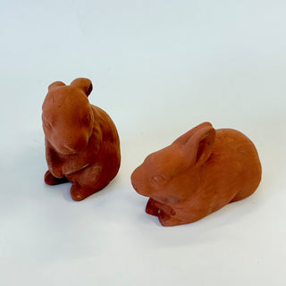 Two terracotta bunny figurines on a white background. One is on its hind legs looking at the other bunny who is in a resting position

House Parts handmade, crafted, artisan, high quality, statues, busts, and figurines.  Unique gifts for everyone. Indoor decorations, Outdoor statues and garden items. Thoughtful gift, animal lovers, rabbit lovers, instead of pet, small business, female owned family business, rabbit, bunny, dog, turtle, frog, clam shell