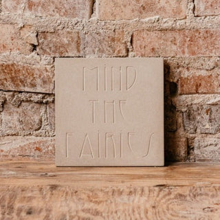 Decorative garden steppingstone that warns you to "Mind the Fairies" set on a wooden tabletop against a brick background

House Parts handmade, crafted, artisan, high quality, statues, busts, and garden and animal figurines.  Unique gifts for everyone. Indoor decorations, Outdoor statues and garden items. Fantasy, whimsical, thoughtful gifts, original gift idea, shop small business, plaster, concrete, Clam shell, Gargoyles, Alice in Wonderland, animal lover gifts, pet memorial